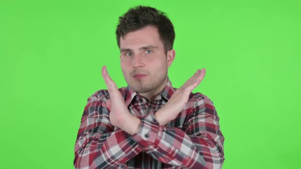 Portrait of Young Man Showing No Sign By Arm Gesture Green Chroma Screen alt