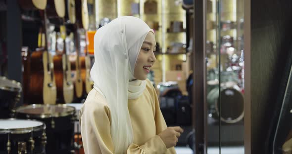 Young pretty muslim woman looking at shop showcase