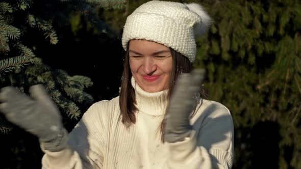 Young Cheerful Woman in Light Clothes Rejoices in the First Snow and Plays in the Forest