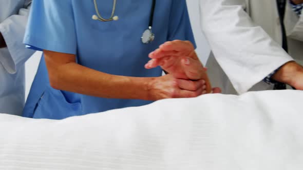 Doctors placing an oxygen mask and adjusting a iv drip to patient in ward alt