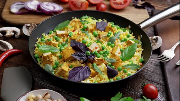 Vegetable Rice with Green Peas Rotates on a Wooden Board alt