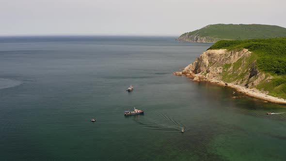 Drone View of a Fishing Schooner Anchored Near a Beautiful Rocky Promontory alt