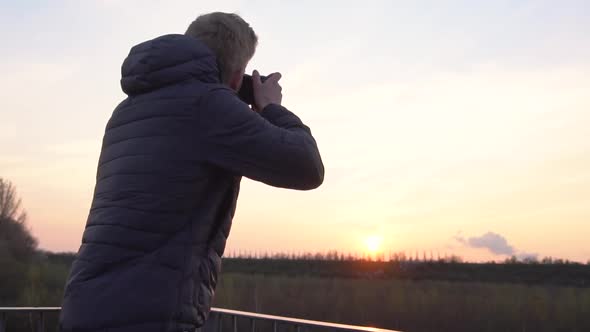 A person is taking photos while standing on a viewing platform. alt