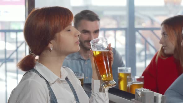 Charming Woman Smiling to the Camera While Drinking Delicious Beer