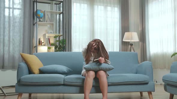 Single Sad Woman Complaining Holding A Pregnancy Test Sitting On A Couch In The Living Room At Home alt