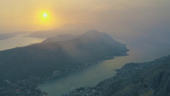 Sunset with fog view of Kotor bay and mountains in Montenegro. Aerial drone view 4K alt