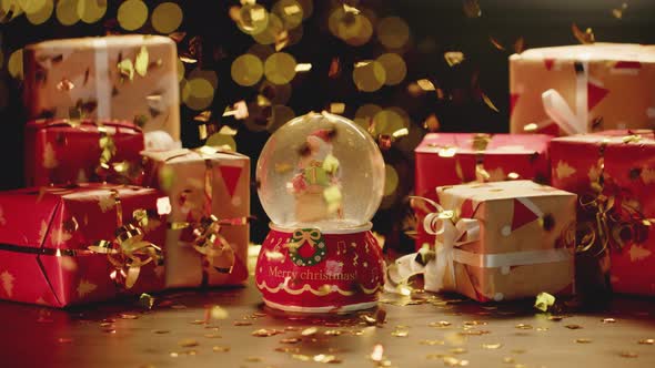 Christmas Snowglobe and Christmas Gifts on Table