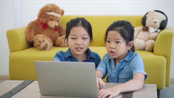 Two Asian girls studying online from home internet, Home Study, Social Distancing, E-learning.