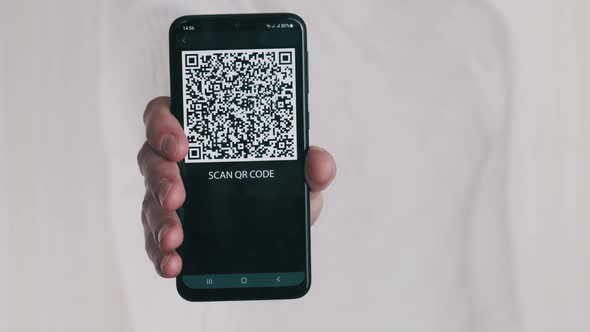 Male Hand Shows QR Code on Smartphone on White Background alt