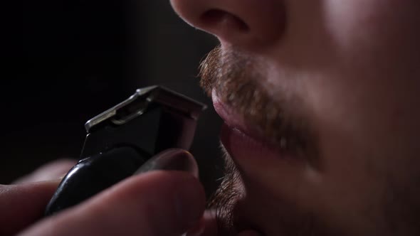 Barber Cuts a Young Man's Mustache with a Shaving Machine