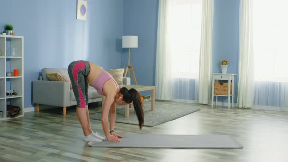 Slim Woman Makes a Deep Breath After Forward Bend alt