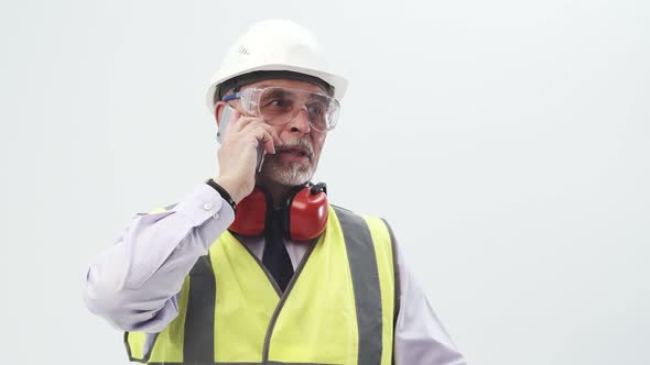 Adult Engineer in a Working Uniform Speaks on the Phone in the Studio on a White Background alt