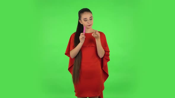 Pretty Young Woman Is Making Herself Manicure with Pink Nail File. Green Screen alt