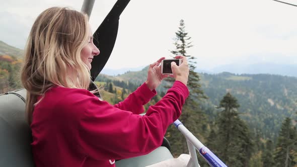 Young Female Tourist Shooting Landscape Using Her Smartphone Camera While Sitting Inside a Modern alt