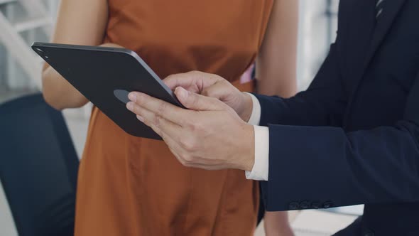 Manager showing plan project to a creative businesswoman in the modern office. alt