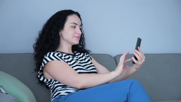 Woman Typing on Phone Sitting on Sofa at Home, Businesswoman Sits at Home Types on Smartphone Checks alt