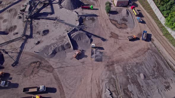 Excavator Loading Crushed Stone Into a Dump Truck in a Crushed Stone Quarry alt