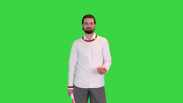 Tennis Player Holding a Racket and Tossing a Ball on a Green Screen Chroma Key