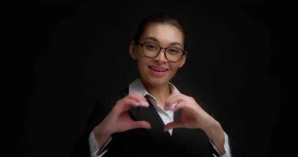 Business Woman Shows a Heart Sign to the Camera Expressing Her Love