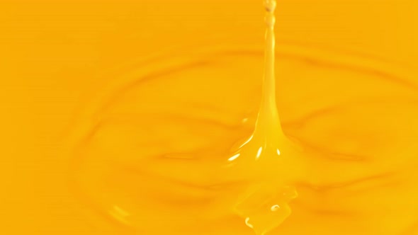 Super Slow Motion Detail Shot of Orange Juice Liquid Drop at 1000 Fps alt