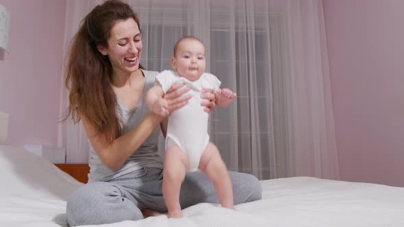 Adorable Infant Baby Girl Daughter Playing Patty with Mom at Home alt