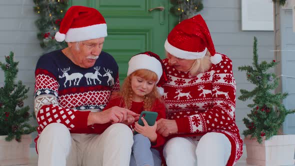 Senior Family Grandparents Granddaughter Purchase Online Christmas Gifts on Mobile Phone Shopping alt