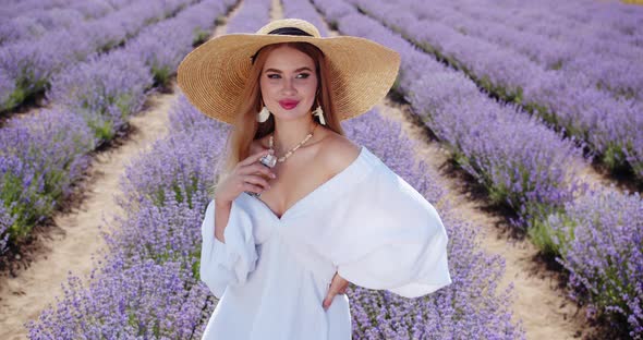 a Girl Applies Perfume on Her Body in a Lavender Field alt