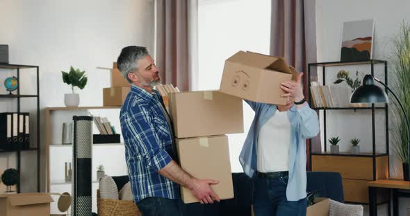 Man Carrying Many Carton Boxes which Pretty Confident Wife Fast Helping to Unload them on the Floor alt