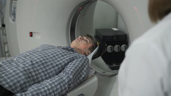 Male Patient On The Ct Or Mri Scanner Machine During X-Ray Process alt
