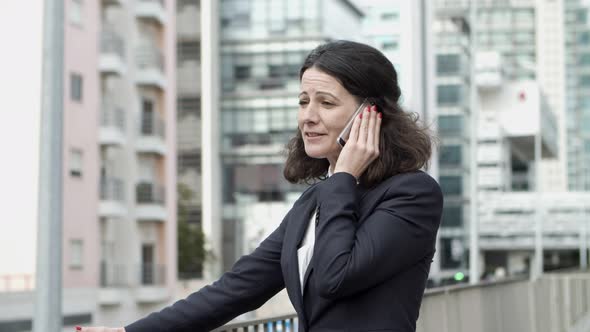 Serious Businesswoman Talking By Smartphone alt