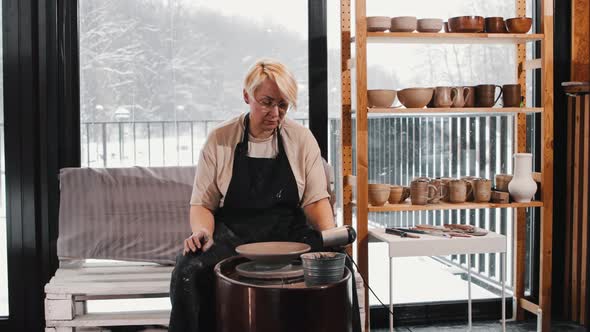 Pottery  an Elderly Woman Heating the Clay Plate on the Pottery Wheel alt