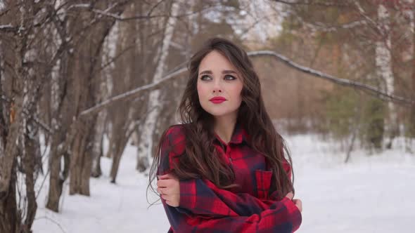 Charming Female with Long Hair Walking in Snowy Forest