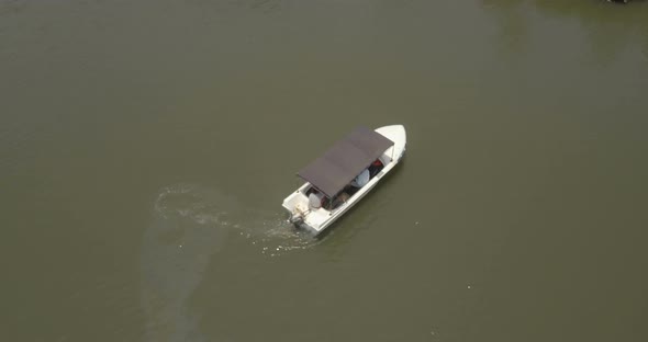 Top View of a Small White Safari Boat Turning Around in the Middle of Big Beautiful Calm Green alt