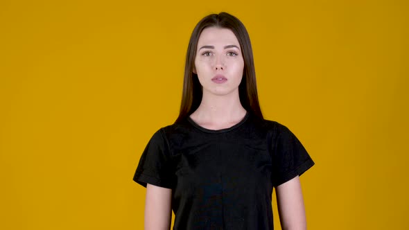 Young girl considering serious plan isolated on yellow background.