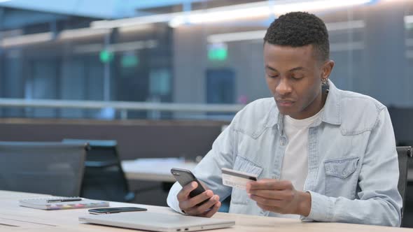 African Man making Online Payment on Smartphone alt