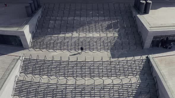 Symmetrical Shot. a Man Climbs the Stairs To the Stadium
