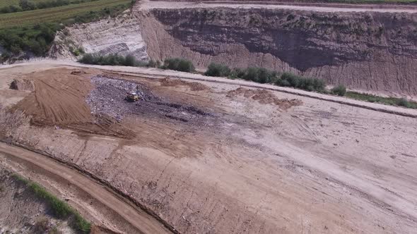 Birds Fly Aroud Garbage Pile on Junkyard Near Working Excavator alt