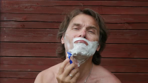 Man Shaving With Blade Shaver Outdoors. 