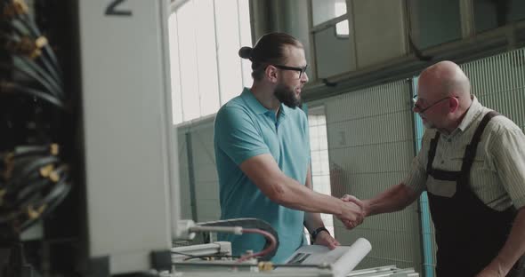 Two Collaborators Shake Hands at the Factory and Inspect Plastic Window Machine alt