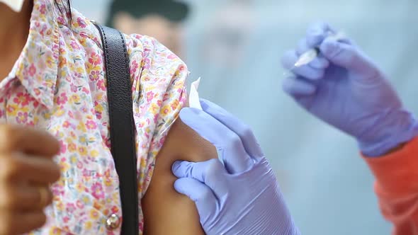 Close-up video of a woman's arm being injected with the corona virus vaccine alt