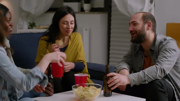 Mixed Race Friends Talking While Relaxing on Couch in Living Room alt