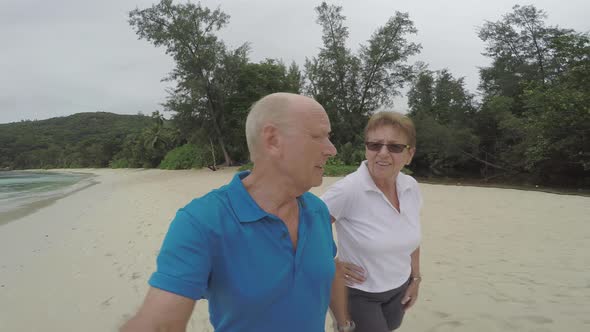 Senior Couple Selfie Walking Along Beach
