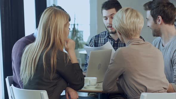 Young Angry Man Discussing Market Research with Colleagues in a Meeting alt