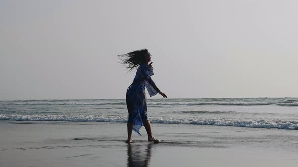 Silhouette of Young Woman Dancing with Gymnastic Elements at the Sandy Beach