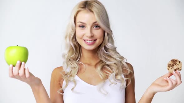 Happy Young Woman with Green Apple and Cookie alt
