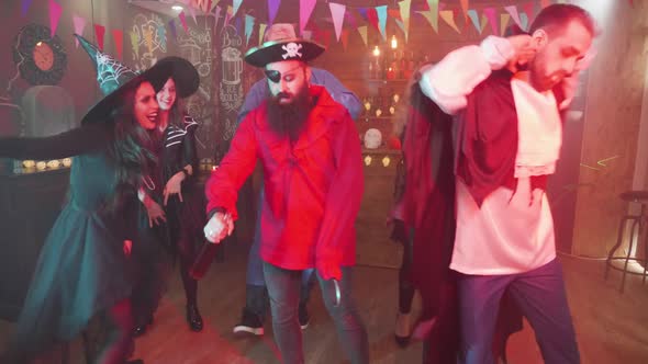 Evil Pirate Dancing in the Middle of a Group of Friends Celebrating Halloween alt