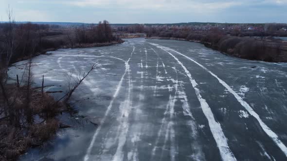 Aerial view of a lake with thin melted ice on the surface.