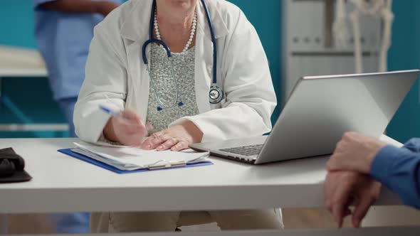 General Practitioner Taking Checkup Visit Notes on Documents alt