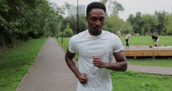 Active African American Man Runner Training Alone Running in Empty City Park alt