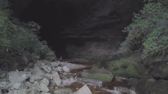 Flying from massive cave along river